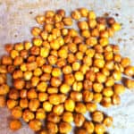 roasted chickpeas on a piece of parchment paper with brown oil