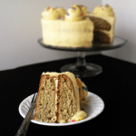 A slice of Roasted Banana Cream Cake on a plate with a fork.