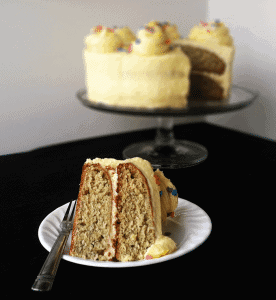 A slice of Roasted Banana Cream Cake on a plate with a fork.