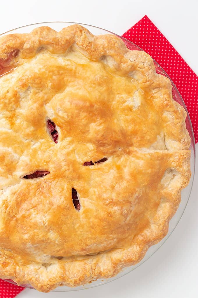 overhead photo of the whole pie on a red linen on a white surface