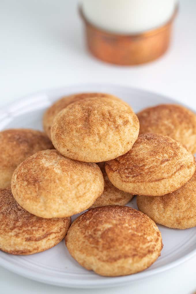 cookies on a large white plate with a glass of milk behind it