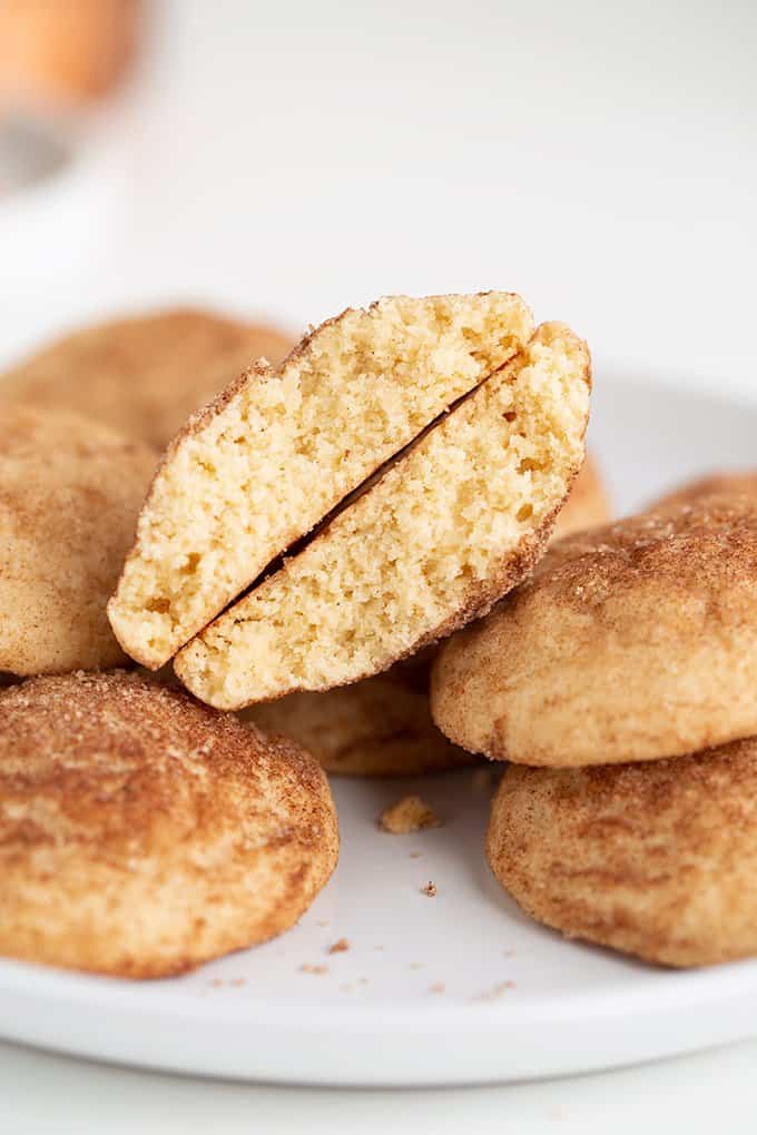 cookie broke in half on top of other cookies on a white plate