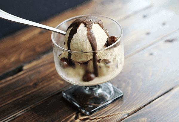 Chocolate covered coffee bean ice cream in a glass.