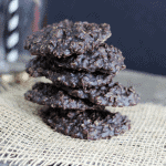 A stack of chocolate no bake cookies on a rustic wooden table.