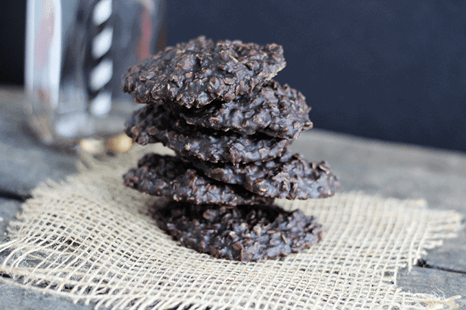 A stack of chocolate no bake cookies on a rustic wooden table.