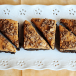 Four pieces of Butterfinger brownies on a white plate.
