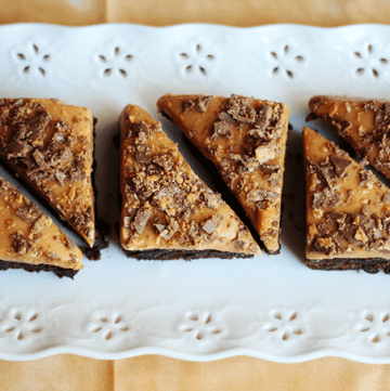 Four pieces of Butterfinger brownies on a white plate.