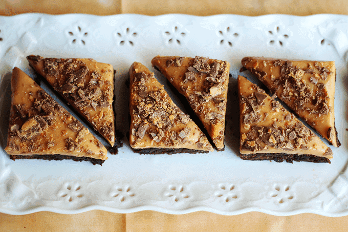 Four pieces of Butterfinger brownies on a white plate.