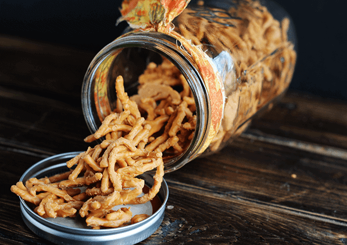 A jar of Chow Mein Candy sitting on top of a wooden table.