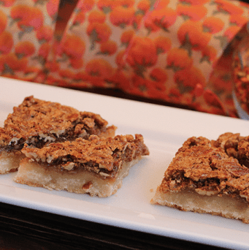 A white plate with three Pecan Pie Bars on it.