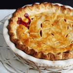 A Raspberry Pie is sitting in a white dish on a table.