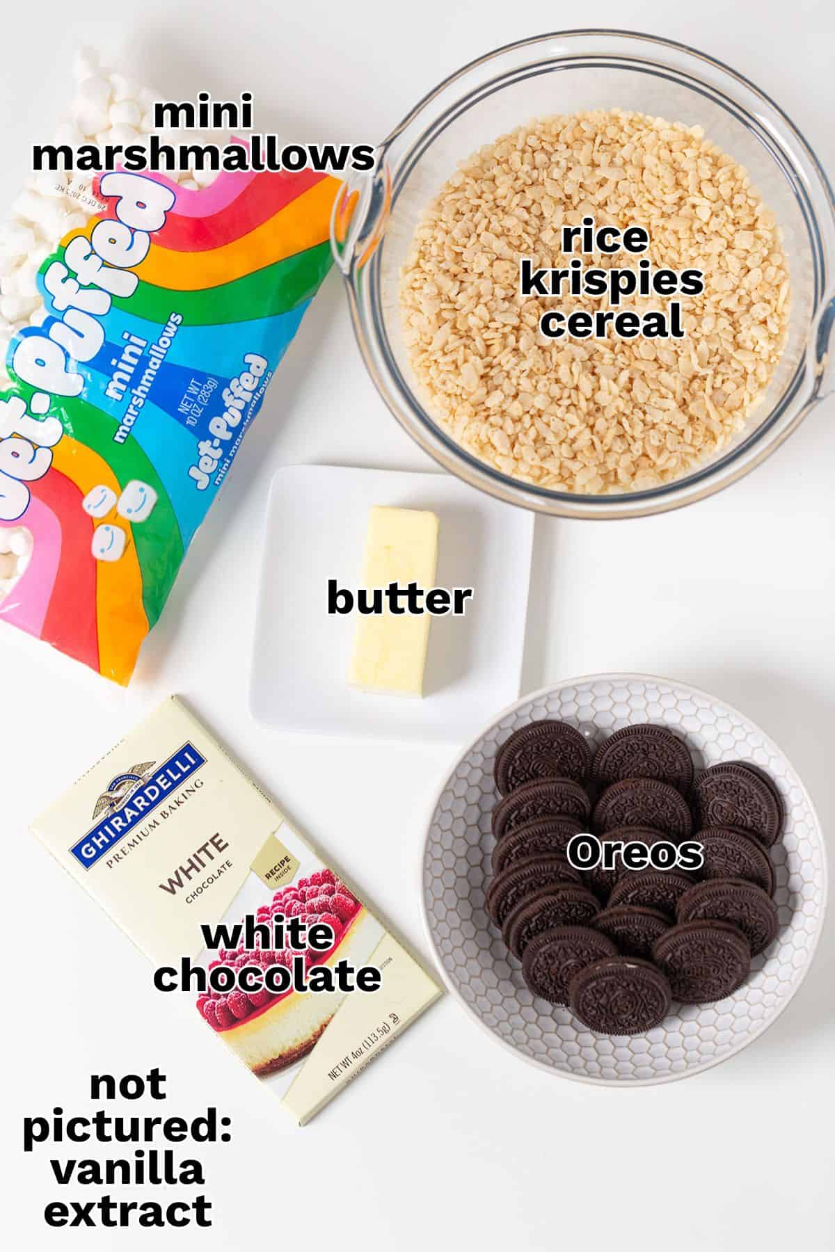 Ingredients for Cookies & Cream Rice Crispy Treats: mini marshmallows, rice krispies cereal, butter, white chocolate, Oreos, and a note that vanilla extract is not pictured.
