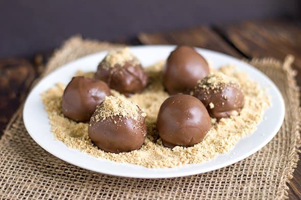 truffles on a white plate with graham cracker crumbs under the truffles