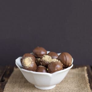 bowl of chocolate covered truffles on burlap on a dark surface