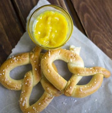 Pretzels with hot pepper butter and a jar of mustard.
