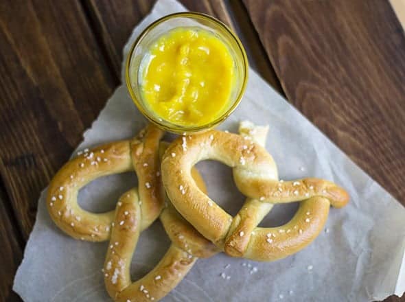 Pretzels with hot pepper butter and a jar of mustard.