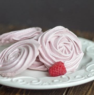 Raspberries and whipped cream dessert served on a white plate