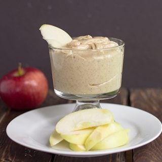 A glass with an apple slice and maple walnut apple dip.