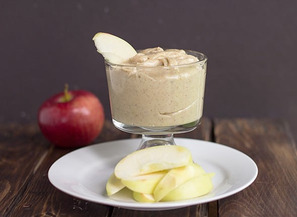 A glass with an apple slice and maple walnut apple dip.