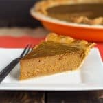 A slice of peanut butter pumpkin pie on a white plate.