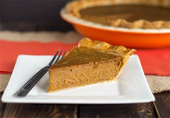 A slice of peanut butter pumpkin pie on a white plate.