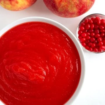 overhead photo of red hot applesauce, candies, and apples