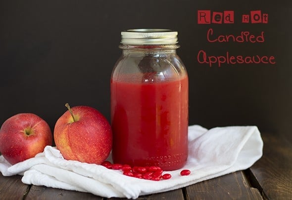 quart jar of red hot applesauce with white fabric, apple, and red hots