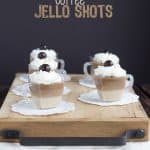 Coffee jello shots served on a rustic wooden tray.