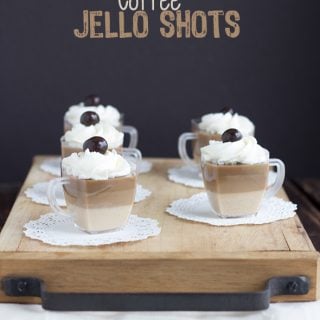 Coffee jello shots served on a rustic wooden tray.