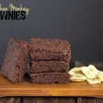 Drunken Monkey Brownies displayed on a rustic wooden cutting board.