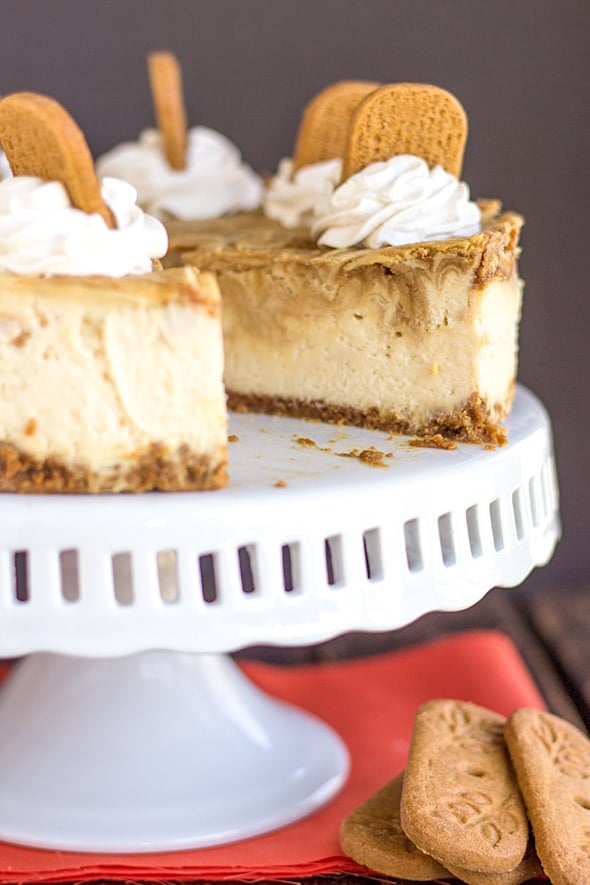 cheesecake on a cake plate with a slice removed 