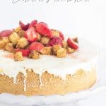 Strawberry shortcake cheesecake on a cake stand.