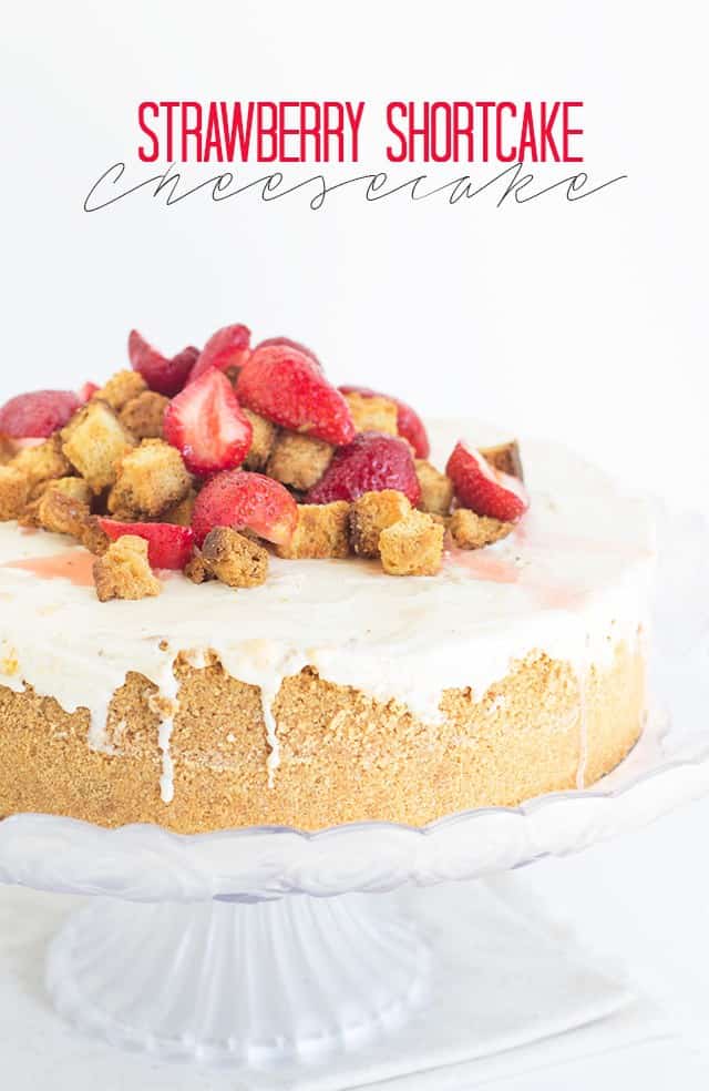 Strawberry shortcake cheesecake on a cake stand.