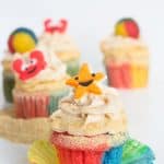Beach-inspired cupcakes adorned with sand and seashells.