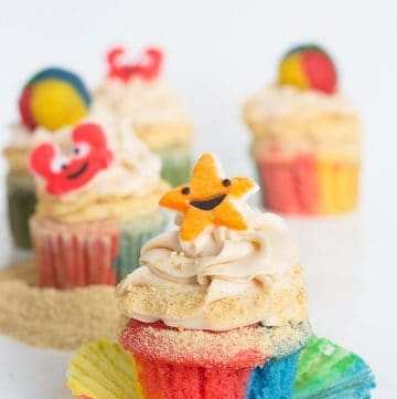 Beach-inspired cupcakes adorned with sand and seashells.