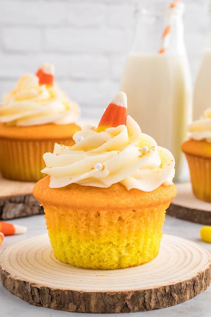 Candy Corn Cupcakes on a wooden cutting board.
