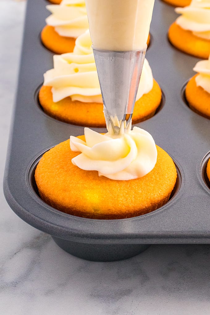 Decorating candy corn cupcakes in a muffin tin.