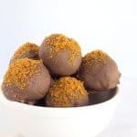 A white bowl filled with pumpkin truffles.
