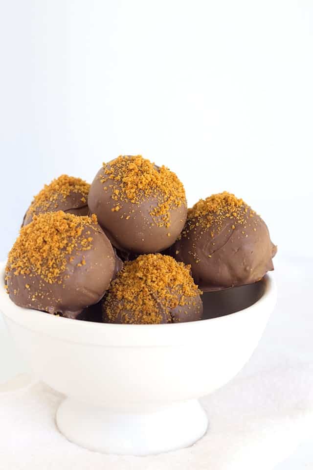 A white bowl filled with pumpkin truffles.