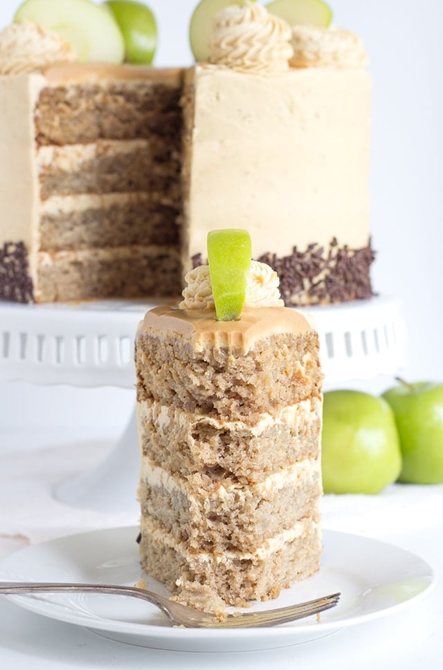 a slice of 4 layer apple cake filled and topped with peanut butter frosting