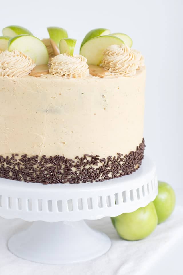 Apple Cake with Peanut Butter Frosting and chocolate jimmies on a white cake stand