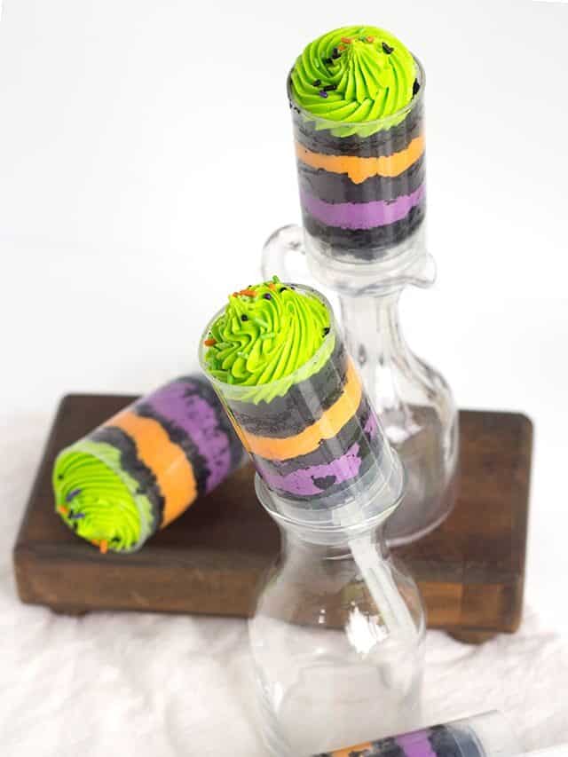 Halloween popsicles in jars with green and purple frosting.