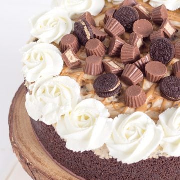 A decadent chocolate cake with creamy peanut butter frosting and adorned with beautiful roses on top.