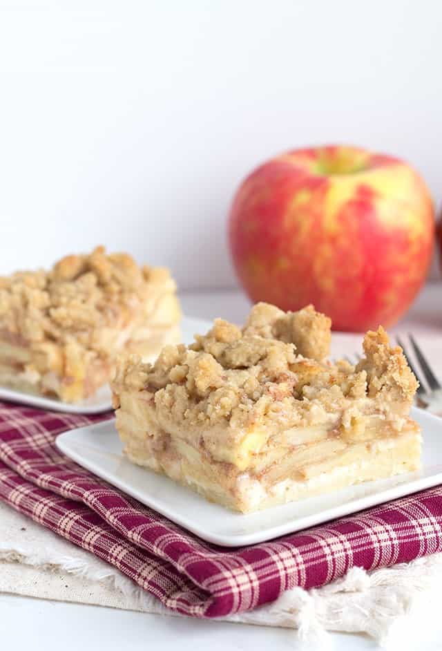 Two slices of apple crumble cake on a plate.