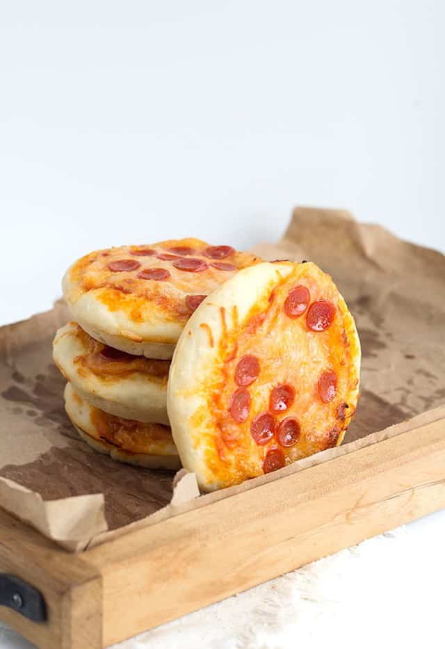 Wooden serving tray holding Mini Pizzas topped with bite sized pepperoni and cheese