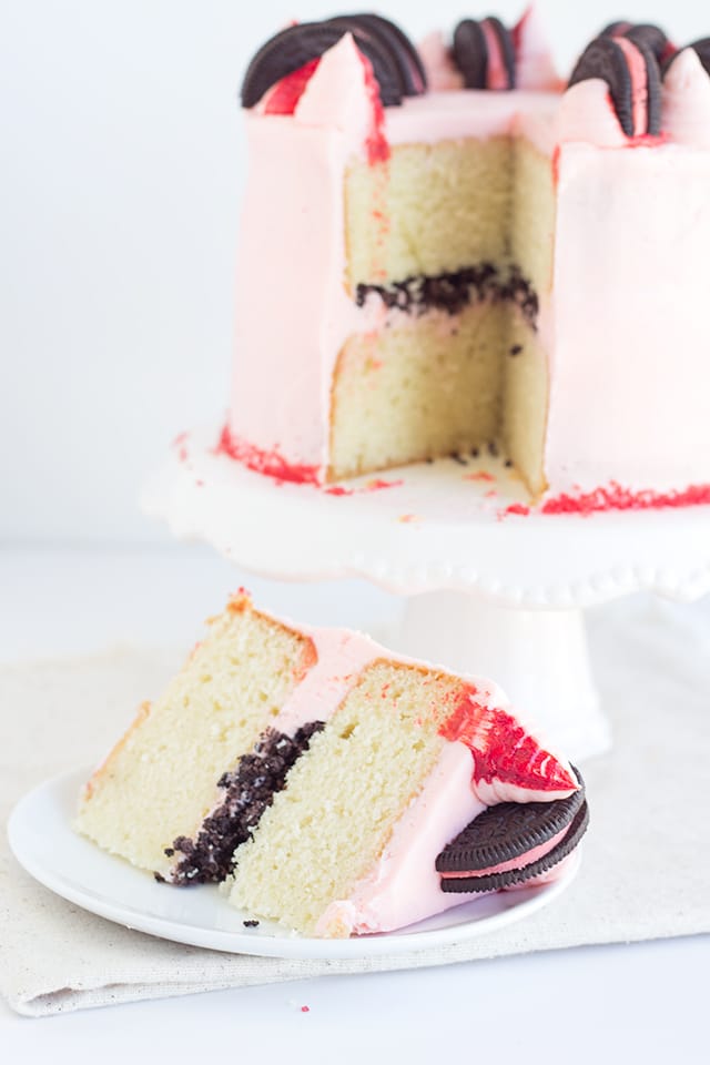 Peppermint Oreo Crunch Cake - Do you need a pretty Christmas cake? This Peppermint Oreo Crunch Cake has a vanilla cake with a peppermint oreo crunch stuffed inside with a baby pink peppermint frosting. It's topped with peppermint Oreos that have been halved and red striped pink frosting peaks. #christmas #recipes #peppermint #dessertfoodrecipes #dessertrecipes #cake #oreo #desserts Peppermint Oreo Crunch Cake - vanilla cake with a peppermint oreo crunch stuffed inside and frosting with a baby pink peppermint frosting.