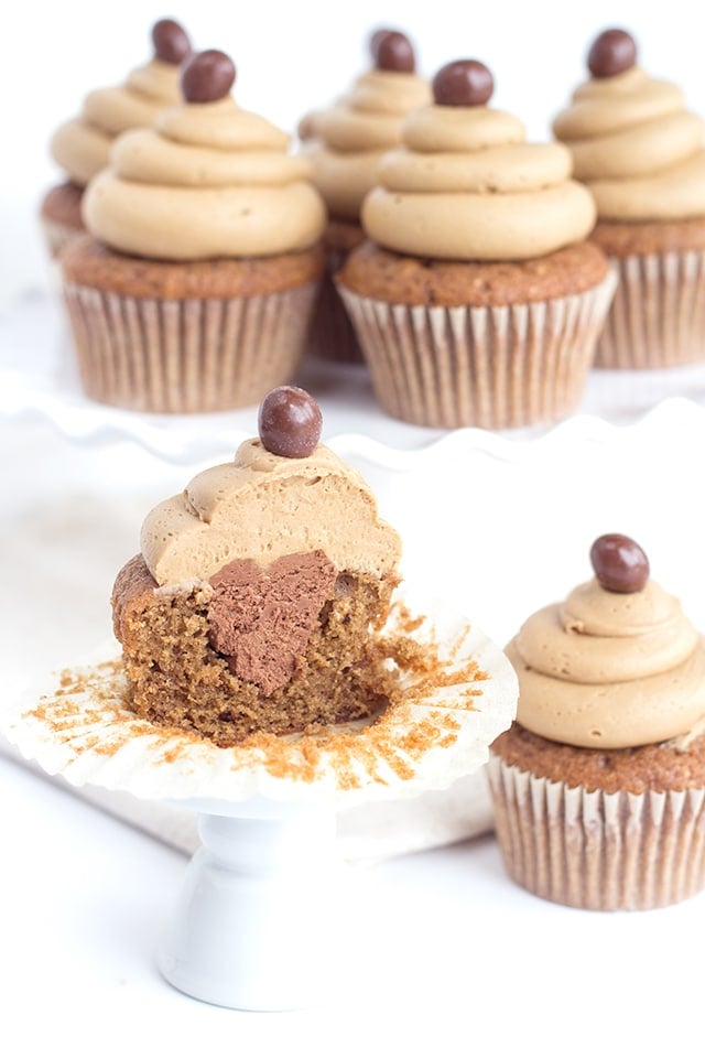 image of coffee cupcakes with coffee buttercream frosting - one cupcake is cut in half