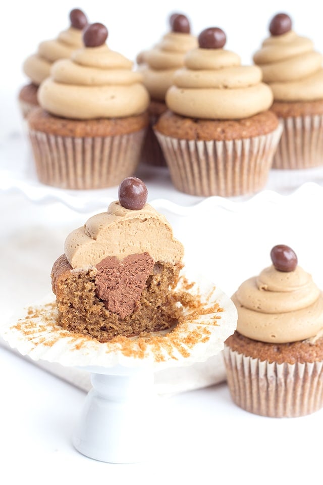 Coffee cupcakes with coffee buttercream are downright delicious. They're the ultimate coffee desserts! Coffee infused cupcakes filled with whipped mocha ganache and topped with coffee buttercream frosting. image of coffee cupcakes with coffee buttercream frosting - one cupcake is cut in half