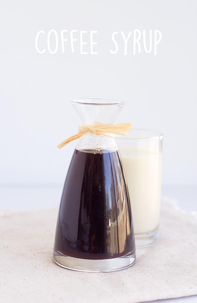 carafe of homemade coffee syrup with a glass of milk behind it