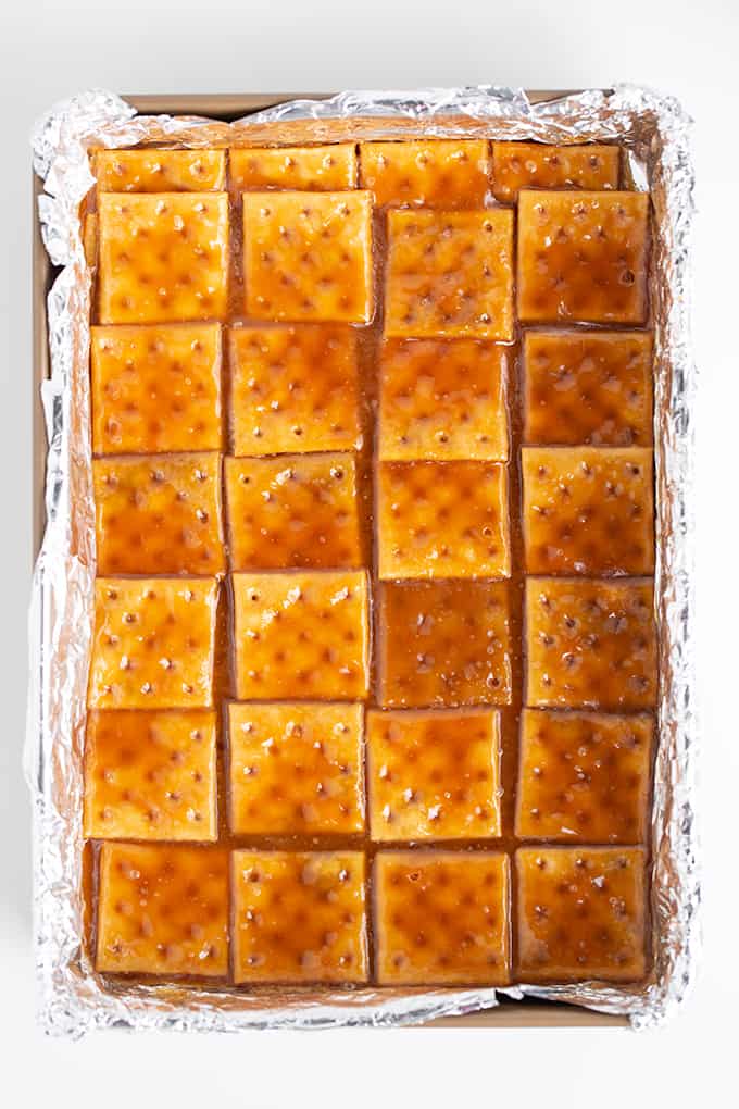 overhead photo of the toffee layer after it was poured on the saltine crackers in the baking pan